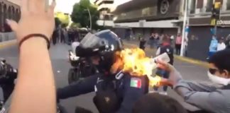 população ateia fogo a um polícia