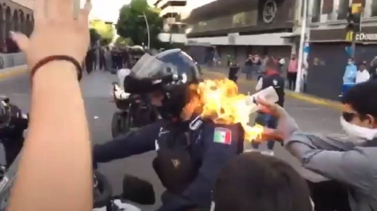 população ateia fogo a um polícia